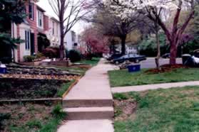 The asphalt trail leads into a concrete sidewalk.  Turn right onto the sidewalk going up the hill.