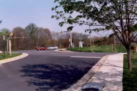 After passing the community center building turn right onto the sidewalk along the access road.