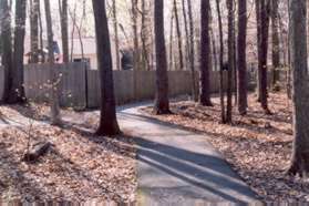 The path turns to the right at a wooden fence.