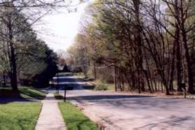 Stay on the sidewalk along this road and cross the next 2 streets.