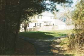 At the next trail intersection keep to the left to walk between the homes.