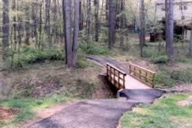 Take the gravel path on the other side of the street and cross the bridge.