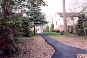 The trail goes up the hill between the houses.