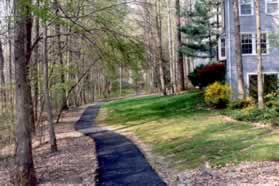 The trail follows the creek on the left and houses on the right.