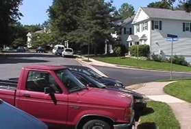 The asphalt trail leads onto a sidewalk. Continue along that sidewalk after crossing the street leading to the right.