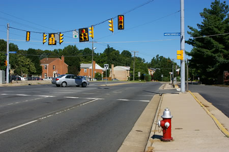 The trail passes Kingsbridge Dr. There is a service road to the right of the sidewalk.