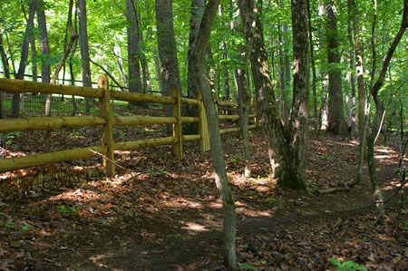 The trail turns to the right after passing by a fence.