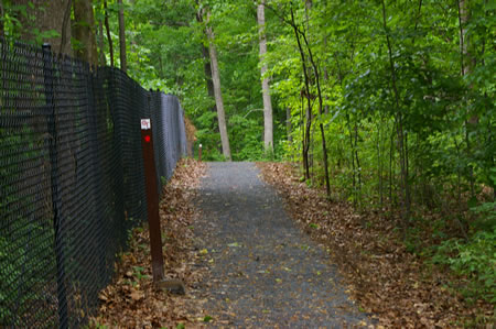 The trail turns left to follow the fence.