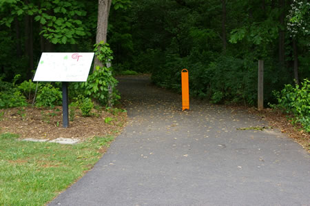 Follow the asphalt trail into the woods.