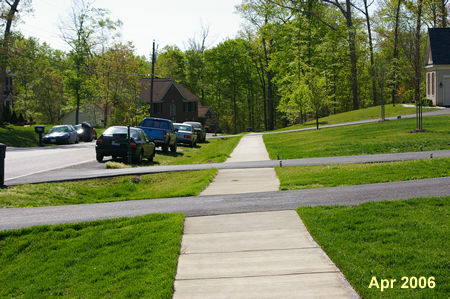 The sidewalk and Creekside View Lane meet. Continue straight on the sidewalk as it follows Creekside View Lane.