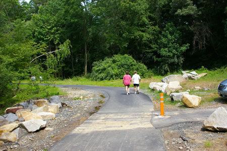 The walk ends at the Camelot Pool parking area. An access road to Camelot Dr. is on your right. Go straight to enter the next section of the walk.