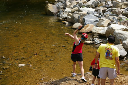 Mom shows how to skip stones in the creek.