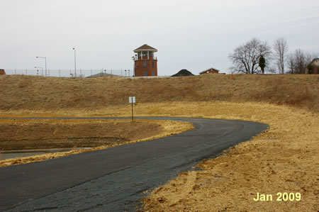 The trail turns left to follow the edge of the retention basin.