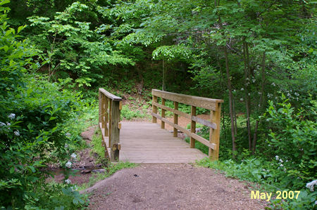 The trail crosses a bridge over a stream.