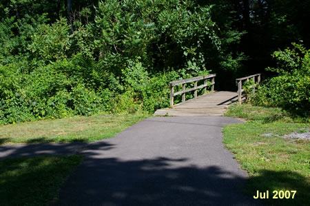 Just prior to a bridge a trail intersects on both sides.  Continue straight across the bridge.