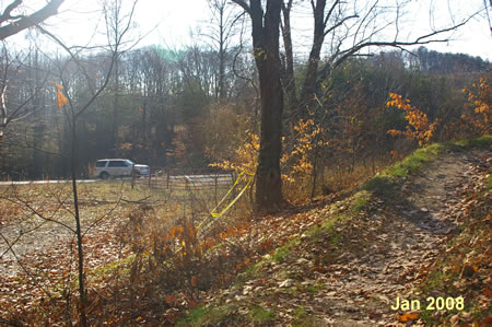 The trail turns and climbs a hill. Lorton Road can be seen on the left.