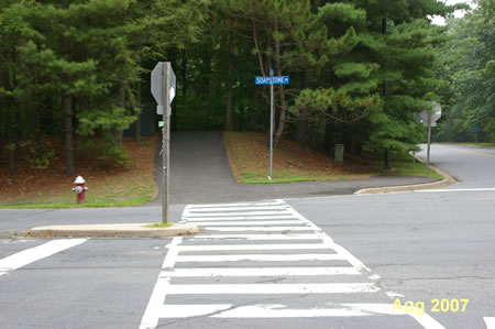 The path crosses Soapstone Dr. and goes up a small hill.