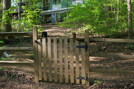 Notice the tennis balls in the basket to the right of the gate. If you throw one of the balls he will fetch it and roll it back down the hill. This is all done quietly with no barking.