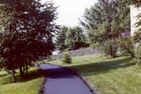 The trail emerges behind some houses.