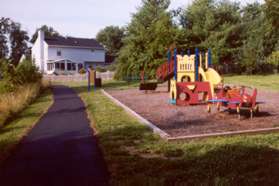 The trail passes a tot lot, goes between the houses and crosses EddysparkDr.