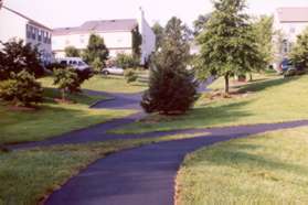 After a short distance the trail intersects with another trail from the left.  Turn sharp left and follow this asphalt trail. Do not take the short trail into the driveway.