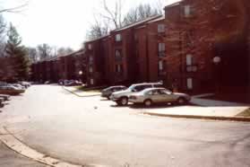 The trail comes out at Shire Ct.  Cross over to follow the sidewalk along the buildings on the other side.