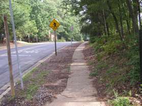 At the intersection with Colts Neck Rd. turn right and follow the sidewalk past the front of the school.