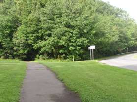 The trail crosses a pipeline. Continue straight and enter the short section of woods.