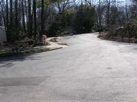 After passing between the houses turn left to follow the sidewalk along South Shore Rd. to the other end of that street.