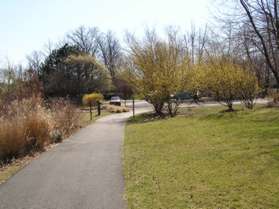 The path passes by a parking area on the right.