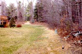 The trail continues across the grass and up the dirt bank to North Shore Dr.