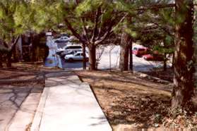 The asphalt path starts at this point and turns to the right and goes behind the houses and down the hill.