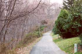 After a short distance homes appear on the right and woods on the left.