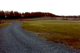 The trail reaches the road entrance to the park. Cross the lawn to the parking area to end the walk.