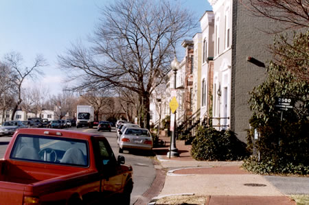 At the top of the hill turn left to follow the sidewalk west along P St.  Buildings should be on your right.