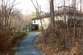 The trail climbs a small hill behind a store.