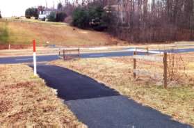 The trail crosses Wiehle Ave at the crosswalk.  Turn right on the other side and follow the asphalt path after crossing the stream.