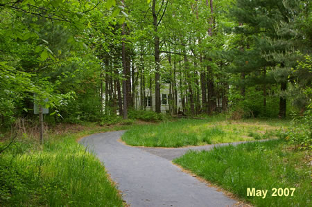 Turn right onto the next intersecting asphalt trail prior to the houses.