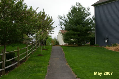 The trail cuts between houses.