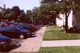 At the front of the building turn right and follow the sidewalk along the parking area.