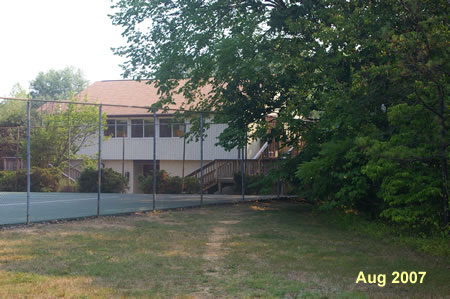 Walk down the steps and continue across the grass toward the clubhouse in the distance.