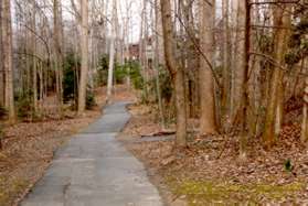 Continue straight past the narrow trail to the right between the buildings.