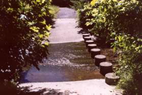 The trail crosses a stream on columns.